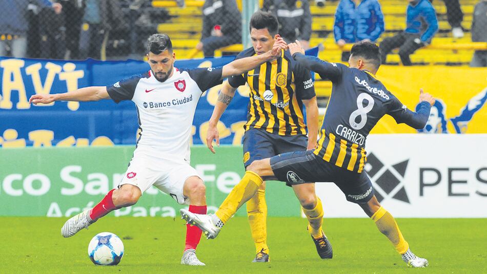 Quignon se prepara para rematar con la derecha, mientras Carrizo intenta interrumpirlo con la pierna izquierda.