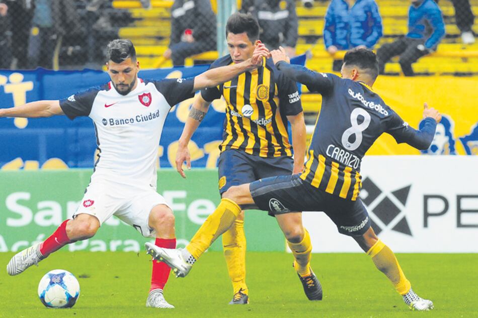 Quignon se prepara para rematar con la derecha, mientras Carrizo intenta interrumpirlo con la pierna izquierda.