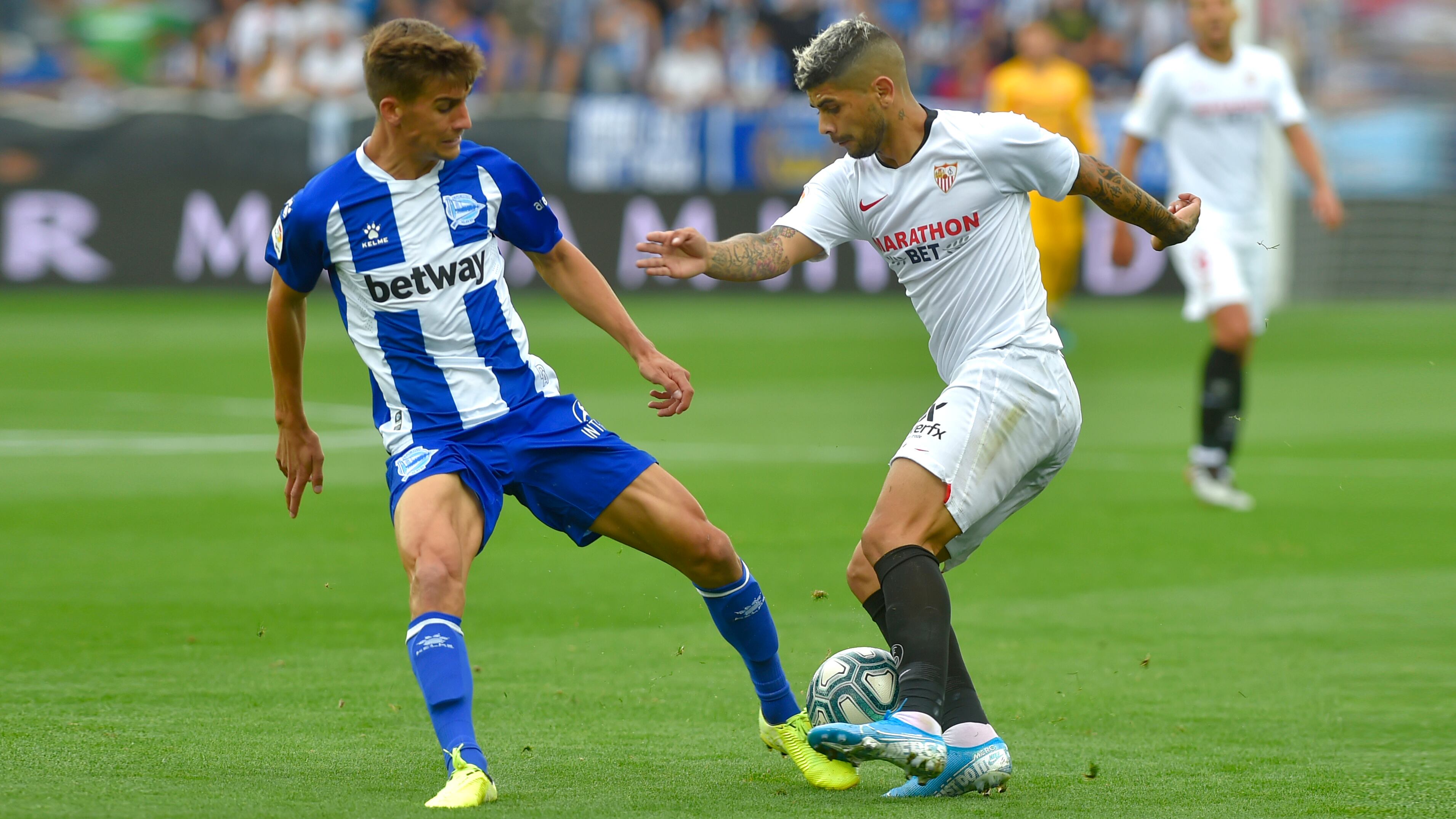 Banega maneja la pelota ante Pina. Ganó Sevilla y es el único puntero en España.