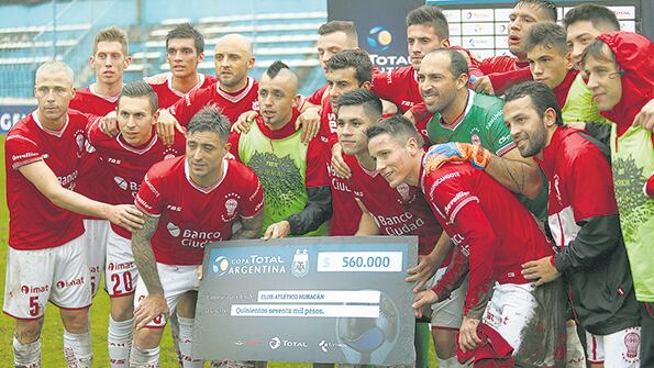Los futbolistas de Huracán festejan el triunfo y el premio.