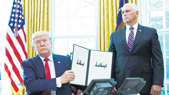Trump, junto a su vice Mike Pence, en el Salón Oval de la Casa Blanca, muestra la orden ejecutiva con las sanciones a Irán.