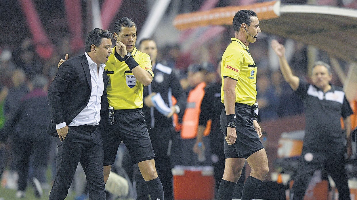 Gallardo protesta ante los árbitros por la mano de Marcone no cobrada.