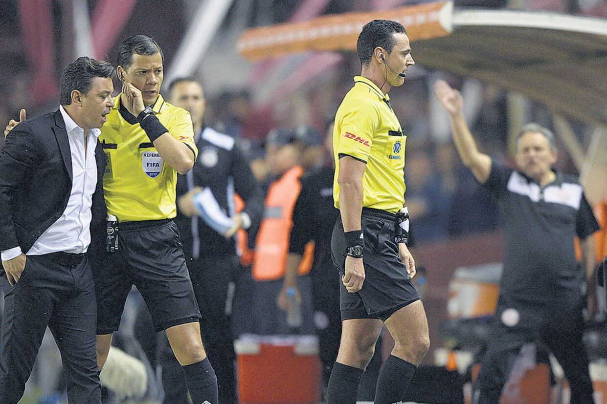 Gallardo protesta ante los árbitros por la mano de Marcone no cobrada.