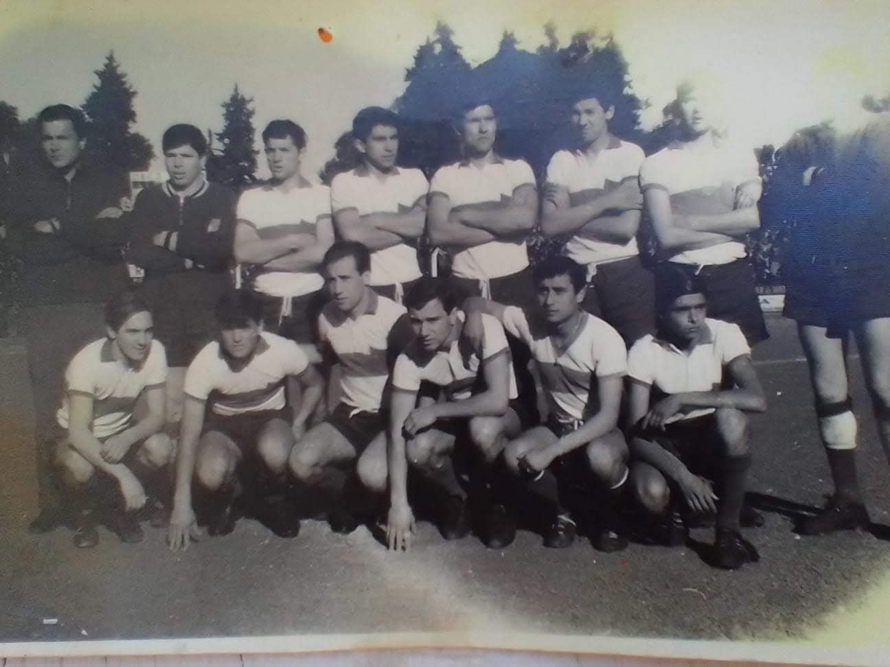 Julio Fabián Benítez Reguera, en una imagen de la Reserva de Gimnasia, agachado y apoyado sobre un compañero