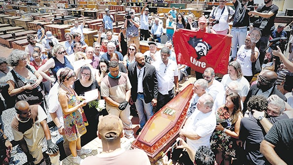 En el entierro de Vavá, un simpatizante de Lula sostiene una bandera del ex presidente.