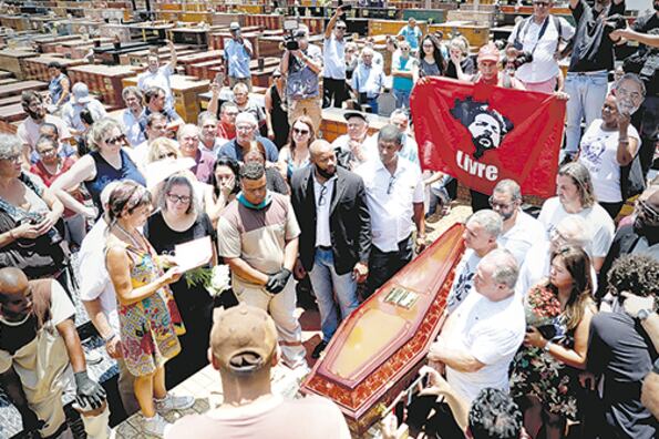En el entierro de Vavá, un simpatizante de Lula sostiene una bandera del ex presidente.