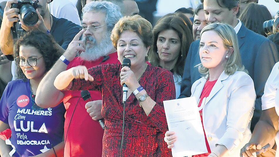 Discurso de Dilma mientras Gleisi sostiene la inscripción de Lula, ayer en Brasilia.