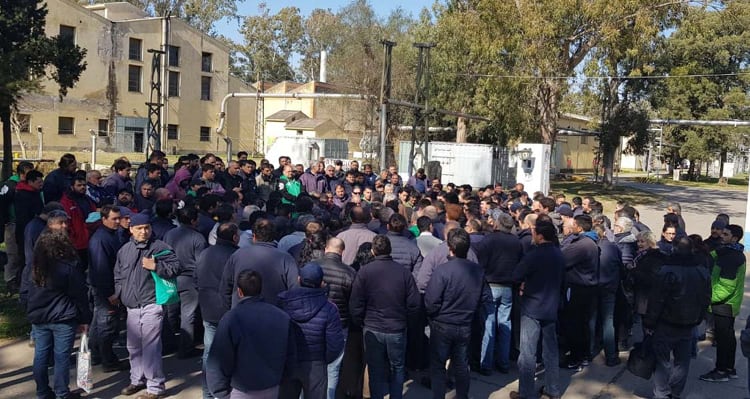 Los trabajadores de la fábrica militar de Villa María escuchan el listado de despidos.