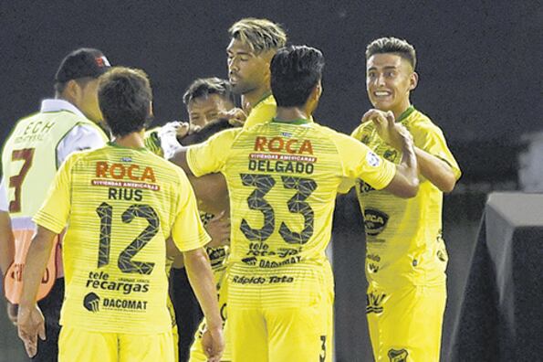 Los jugadores de Defensa felicitan al paraguayo Rojas, que marcó el tiro libre del triunfo en el Monumental.