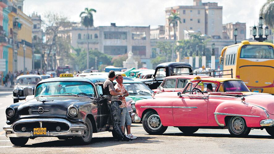 Dos taxistas esperan la llegada de turistas en el centro de La Habana.