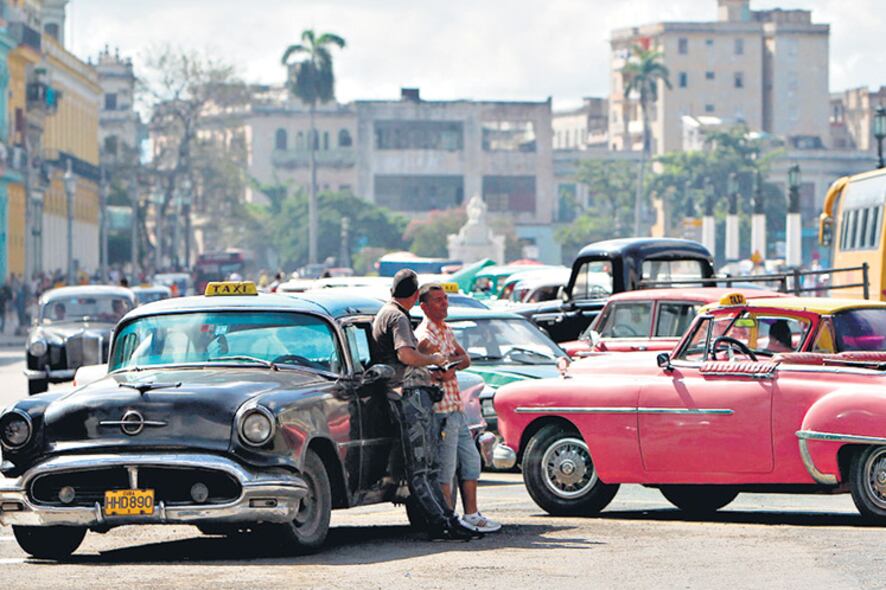 Dos taxistas esperan la llegada de turistas en el centro de La Habana.