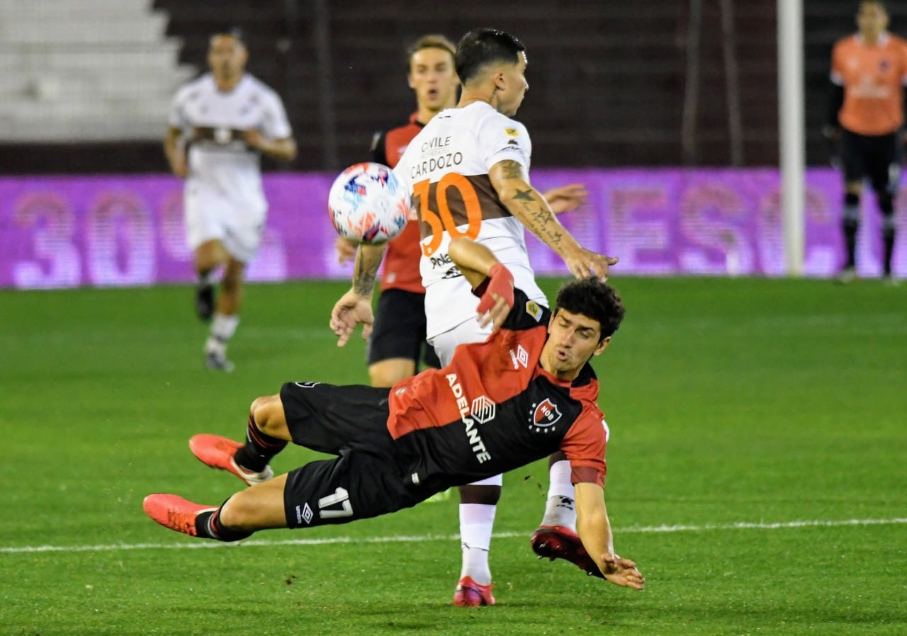 Giani busca la pelota con Cardozo. Newell's encontró el triunfo sobre el final.