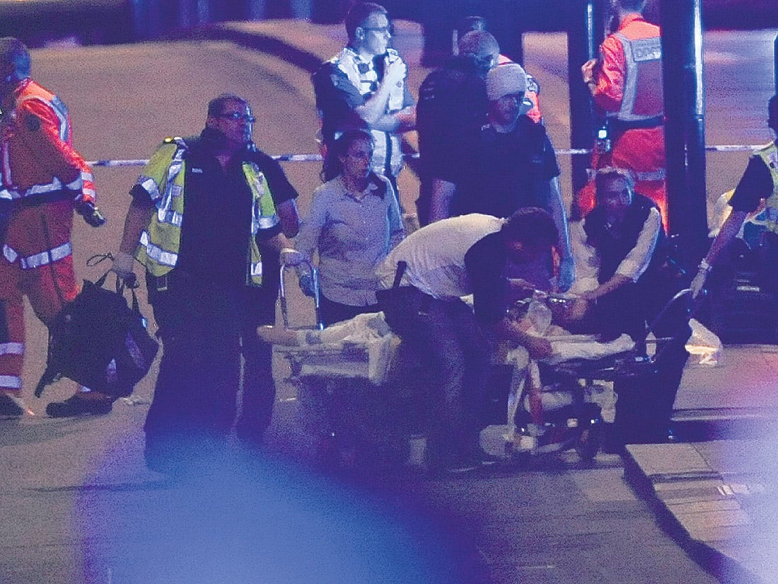 Policías y enfermeros atienden a una de las víctimas del atentado en el puente de Londres ayer a la noche.