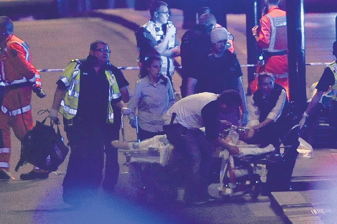 Policías y enfermeros atienden a una de las víctimas del atentado en el puente de Londres ayer a la noche.