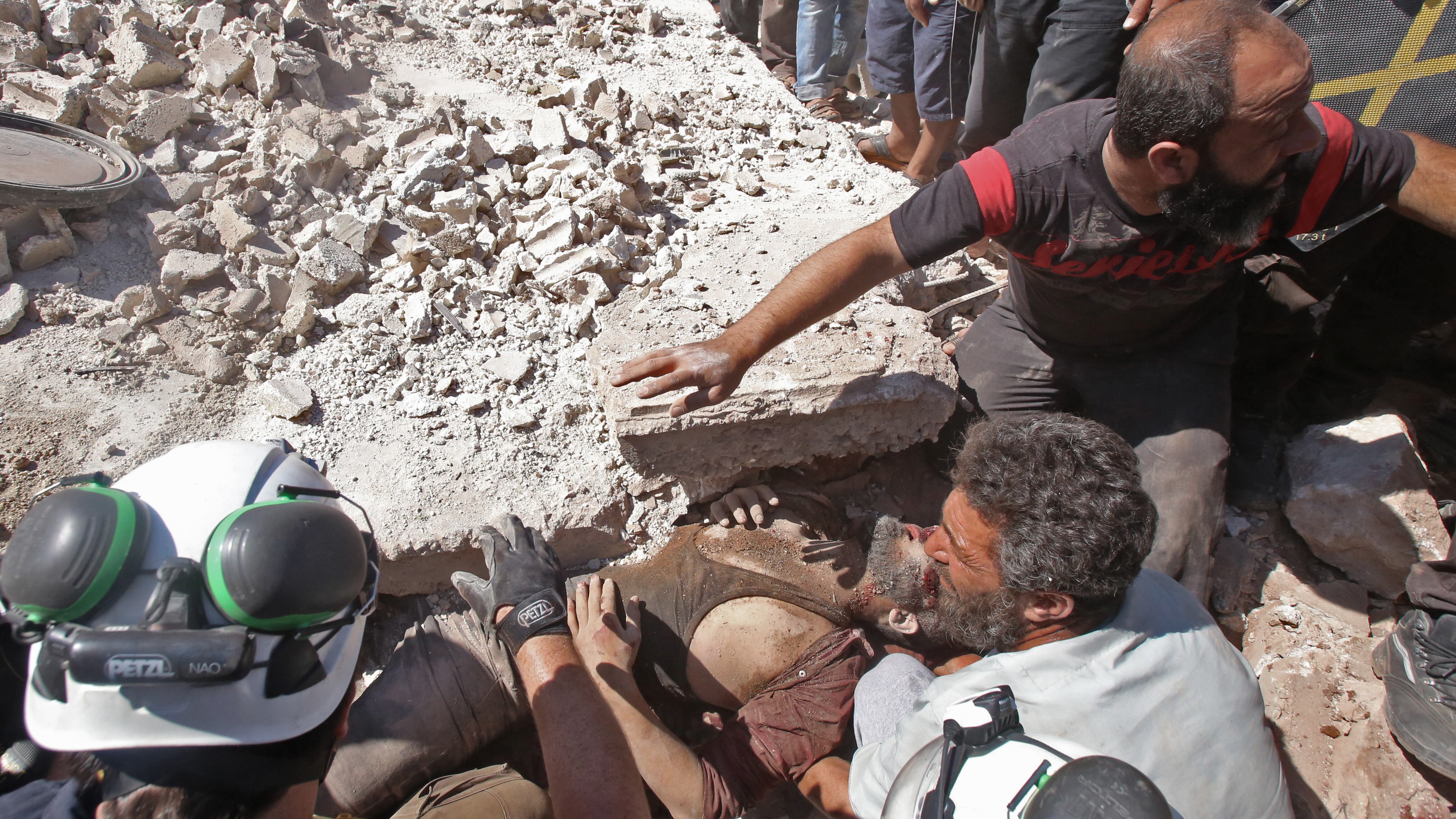 Rescatistas remueven a un herido de los escombros después de un bombardeo en Kafar roma, estado de Idlib.