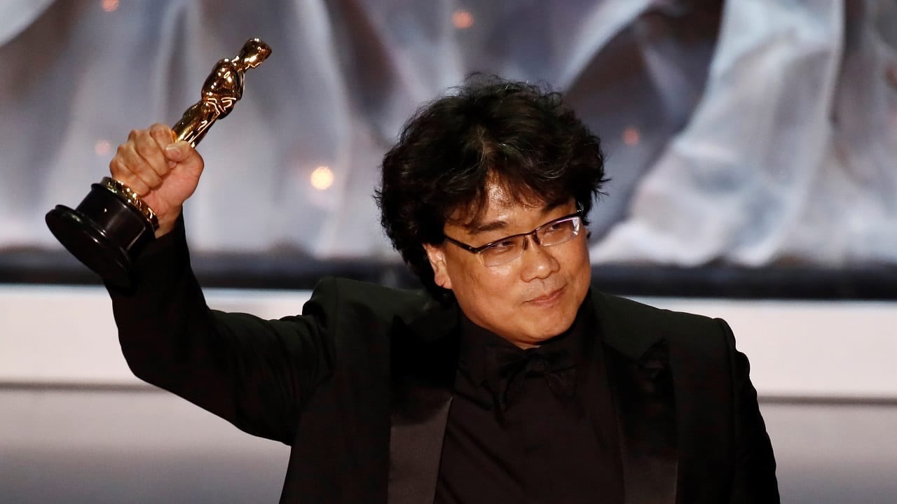 Bong levanta su puño en alto, aferrando uno de sus cuatro premios Oscar.