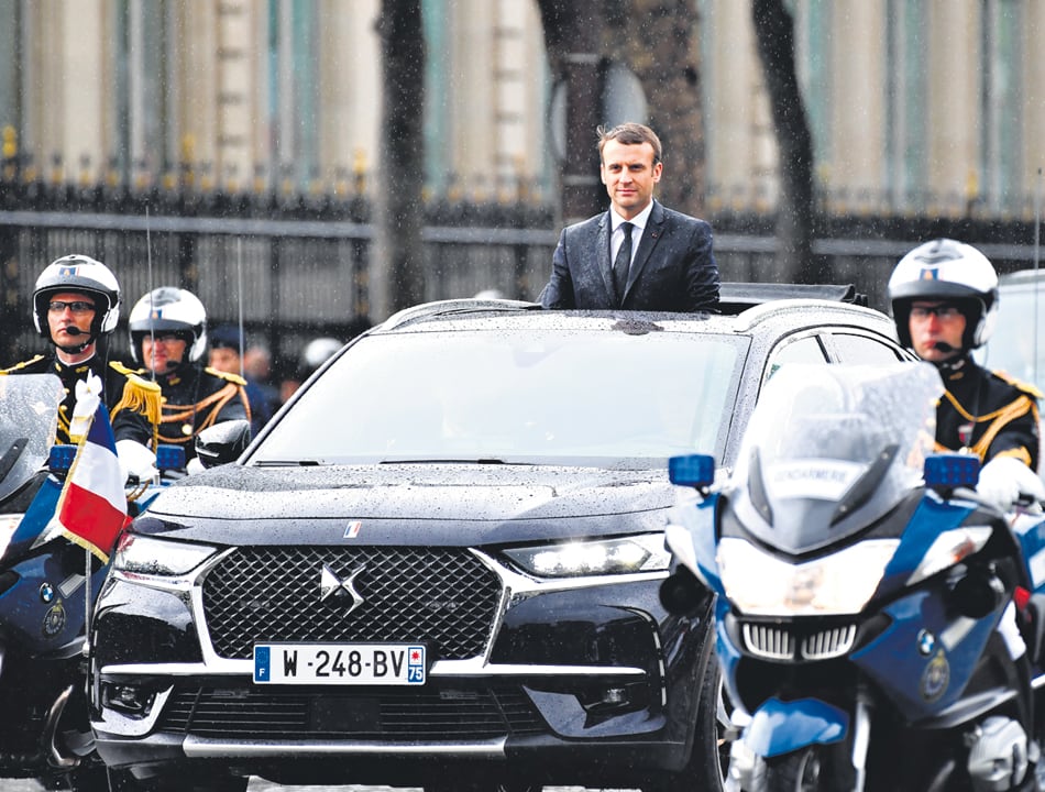 Bajo una fina lluvia, Macron recorrió la famosa avenida parisiense Champs Elysées en un vehículo descubierto.