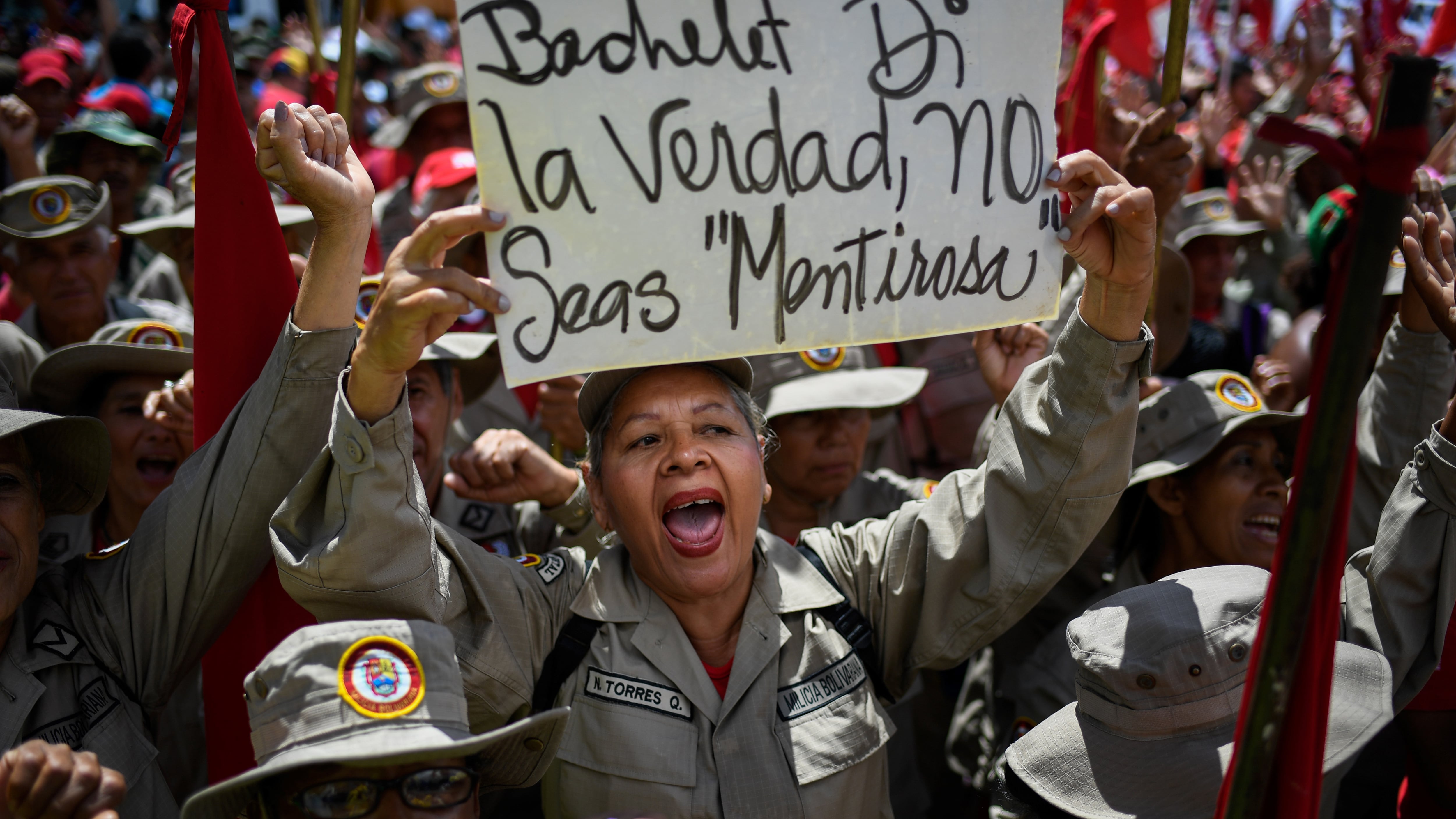 Ua integrante de la milicia bolivariana sostiene un cartel criticando a Bachelet en la marcha de hoy en Caracas