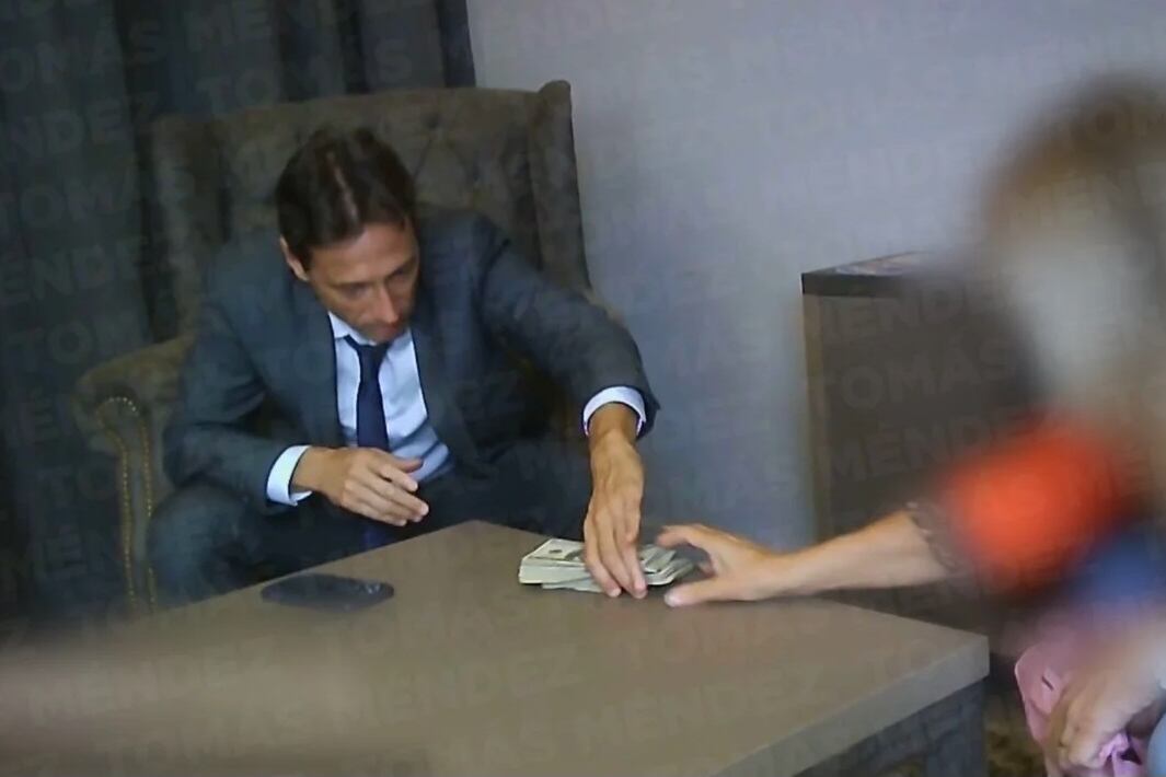 Moretti tomando los dólares en una de las escenas de la ya afamada cámara oculta.