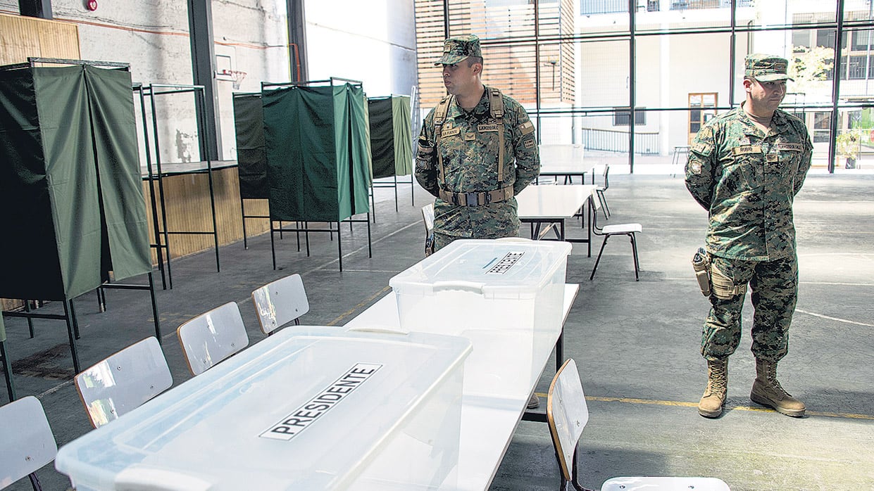 Soldados chilenos vigilan las urnas en un centro de votación ubicado en un colegio secundario de la capital chilena.