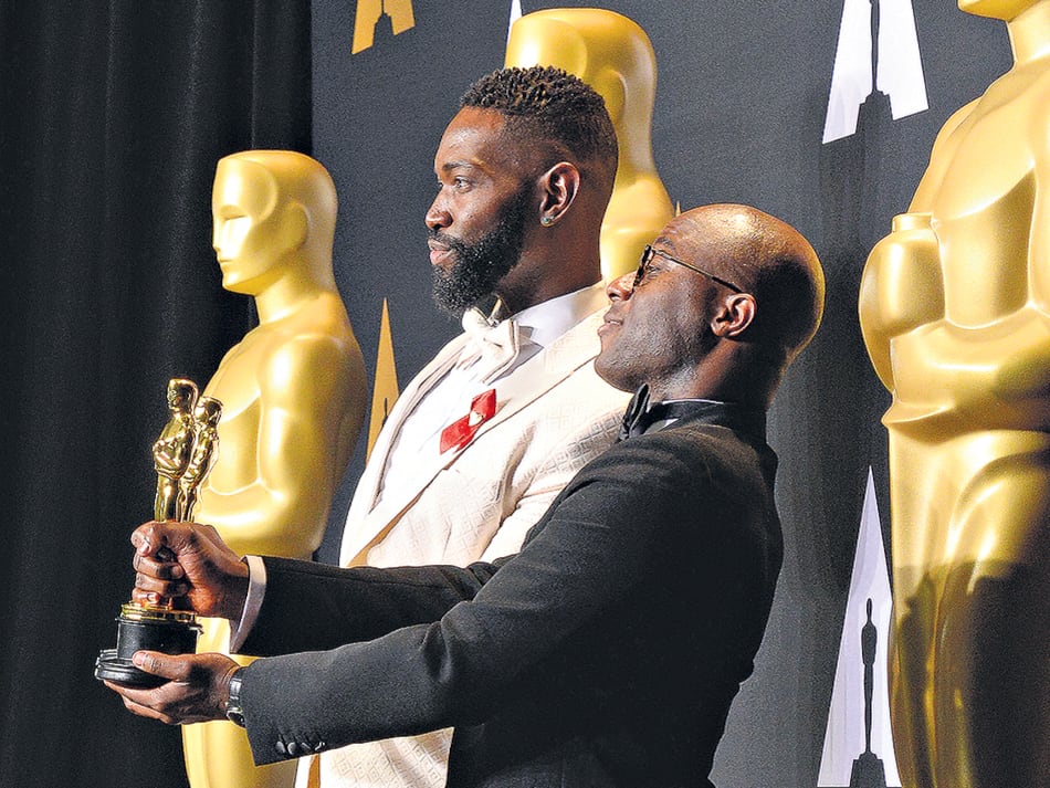 Tarell Alvin McCraney y Barry Jenkins festejan el Oscar al mejor guión adaptado.