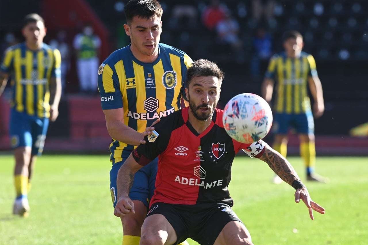 Ignacio Scocco (36 años) aguanta la pelota ante la marca de Facundo Almada (23)
