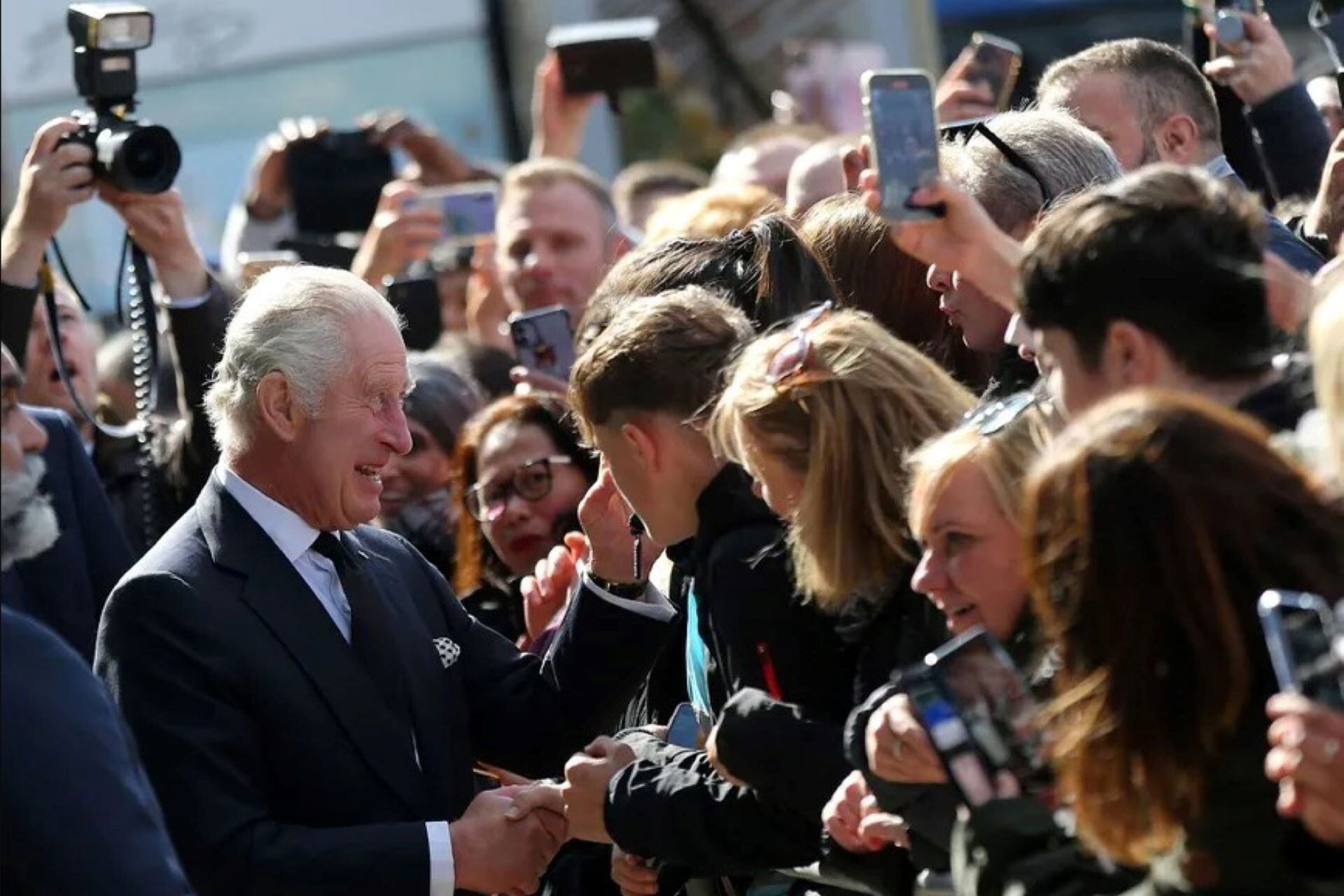 El rey Calos III saludando a las personas que esperan en colas de hasta 14 horas, para entrar en la capilla ardiente a despedirse de la Reina Isabel III. (Foto: AFP)
