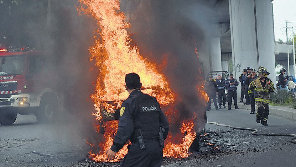 Policías y bomberos mexicanos trabajan en la escena del tiroteo entre marinos y una banda narco en el D.F.
