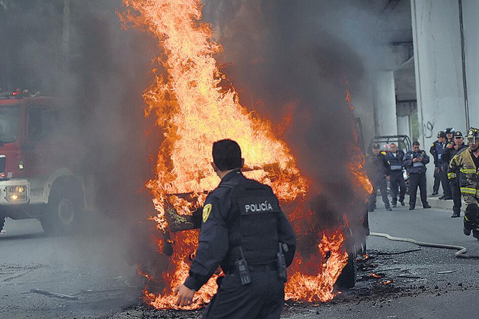 Policías y bomberos mexicanos trabajan en la escena del tiroteo entre marinos y una banda narco en el D.F.