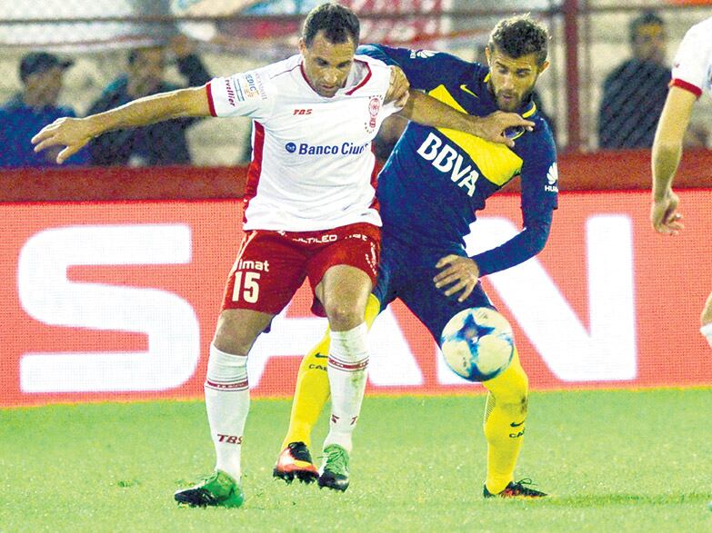 Mariano González trata de controlar la pelota ante la marca de Gino Peruzzi.