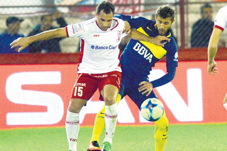 Mariano González trata de controlar la pelota ante la marca de Gino Peruzzi.