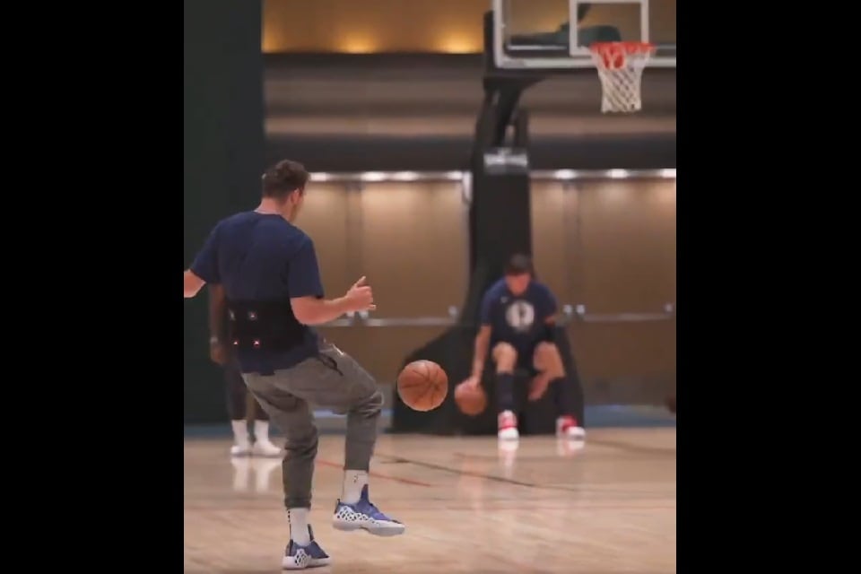 Doncic se prepara para conectar la pelota con el pie. Fuera de foco, el gigante serbio Boban Marjanovic.