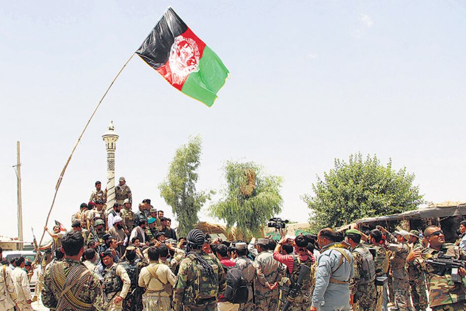 Un destacamento de fuerzas de seguridad de Afganistán iza la bandera nacional en una plaza de la provincia de Nawa.