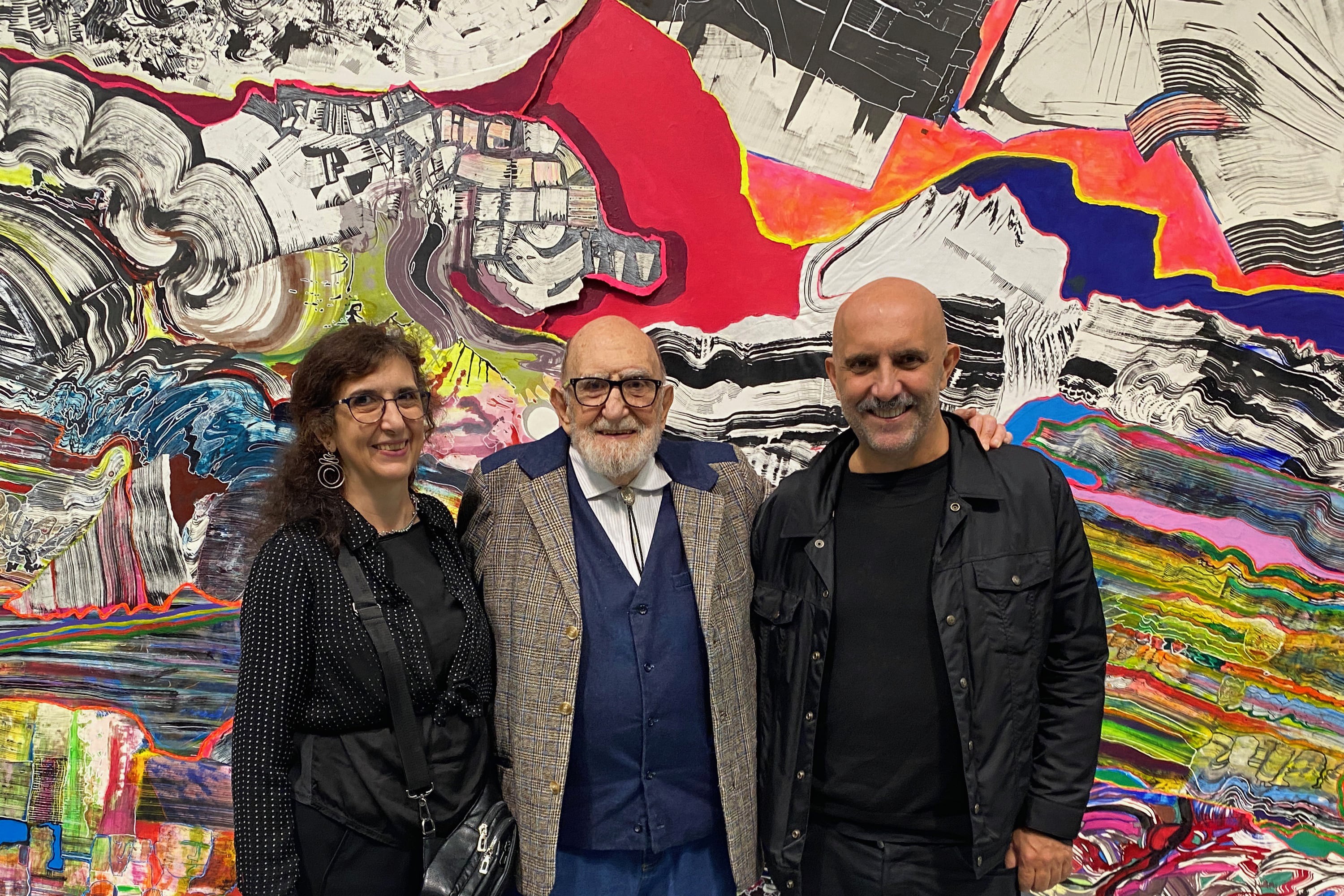 Yuyo Noé con sus hijos Paula y Gaspar en la exposición "Visión quebrada" (2023). Gentileza archivo Fundación Luis Felipe Noé. Abajo: "Eternidad", pintura de Noé, 3,25 mts x 4,75 mts (2023).