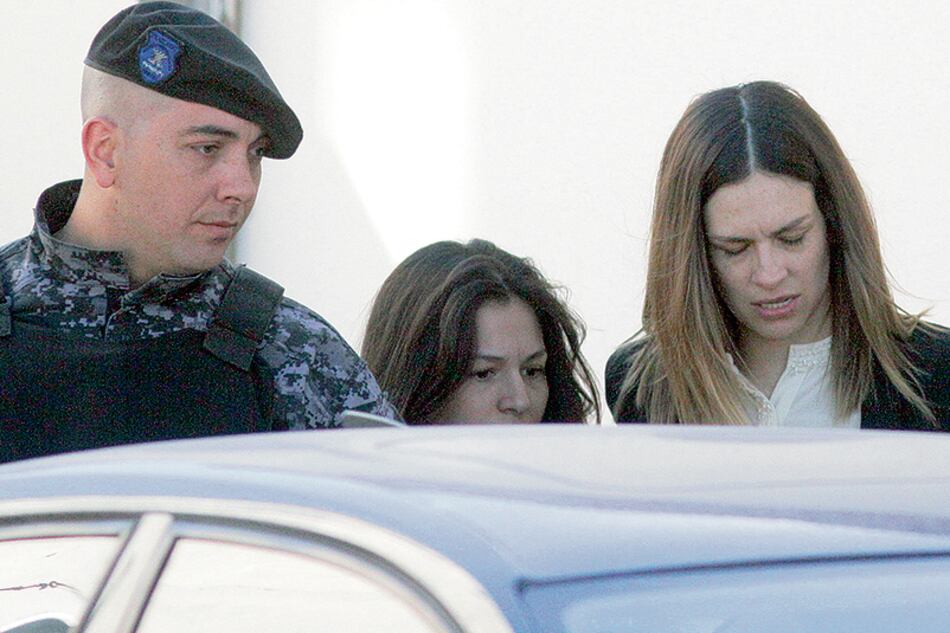 Julieta Silva (der.) sale del juzgado y es trasladada por la policía.