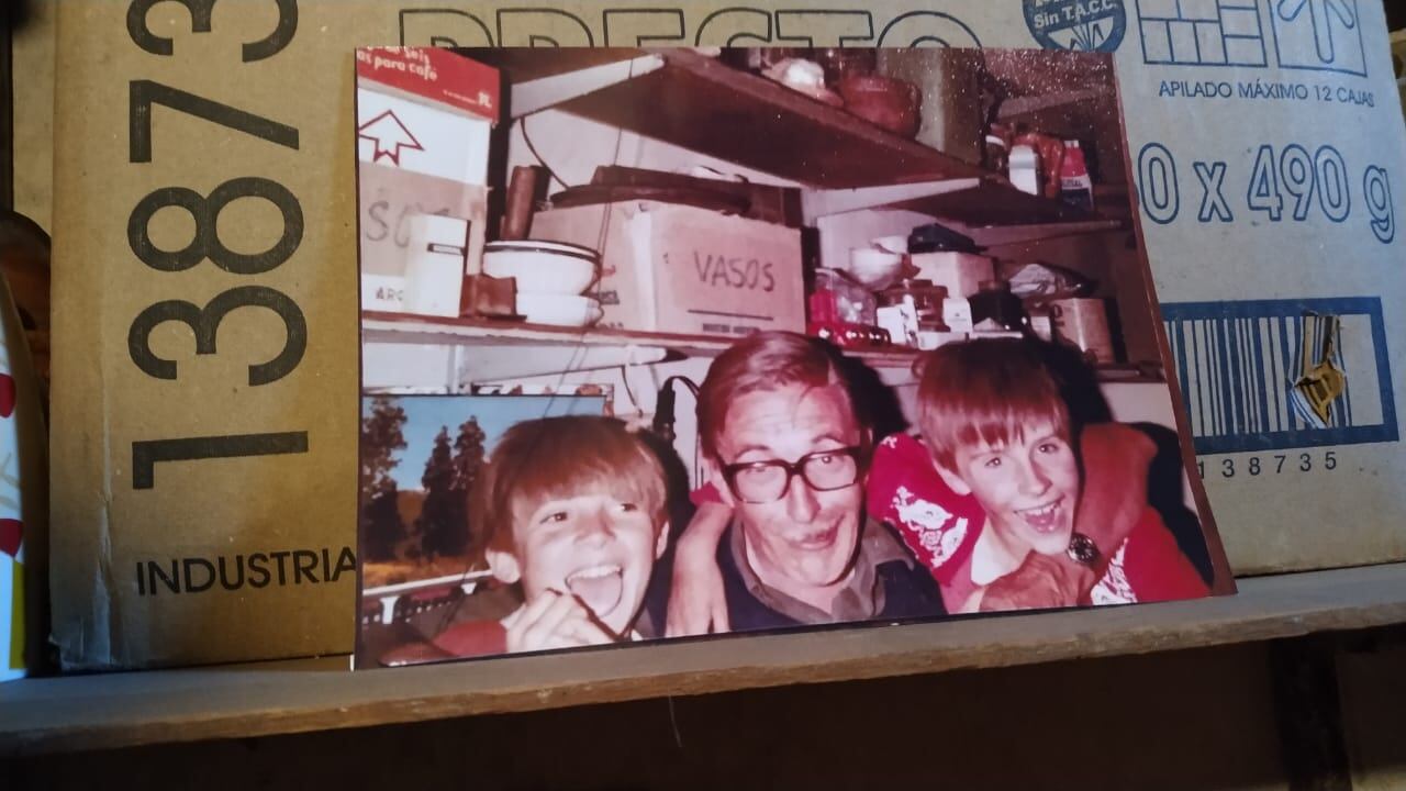Fotografía de Rodolfo junto a sus hijos en un estante de la casa