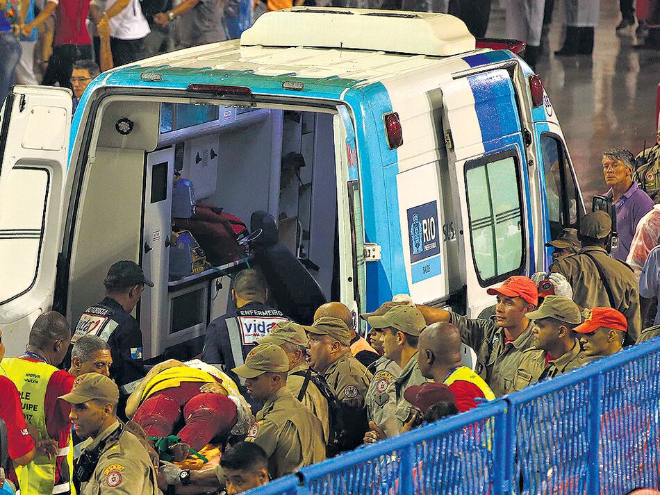 Una ambulancia retira heridos luego del vuelco de la carroza de la Tuiutí.