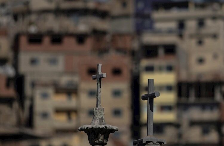 Las cruces de tumbas en un cementerio, con una favela carioca de fondo.