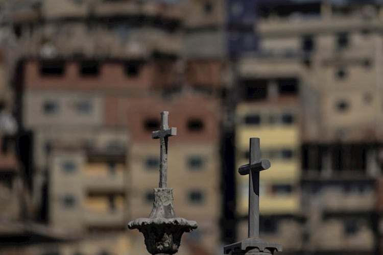 Las cruces de tumbas en un cementerio, con una favela carioca de fondo.
