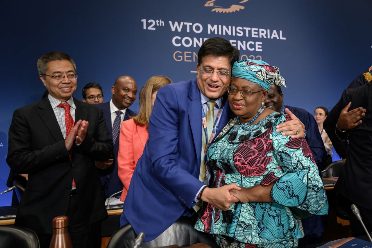 La directora de la OMC, Ngozi Okonjo-Iweala, saluda tras el acuerdo al ministro de Comercio indio, Piyush Goyal.