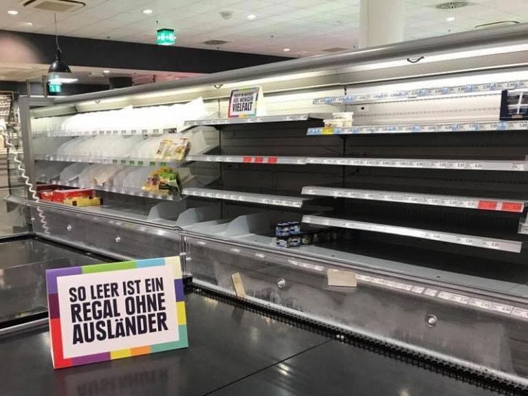 "Así de vacías se ven las estanterías sin extranjeros", dice el cartel frente a la góndola sin productos.