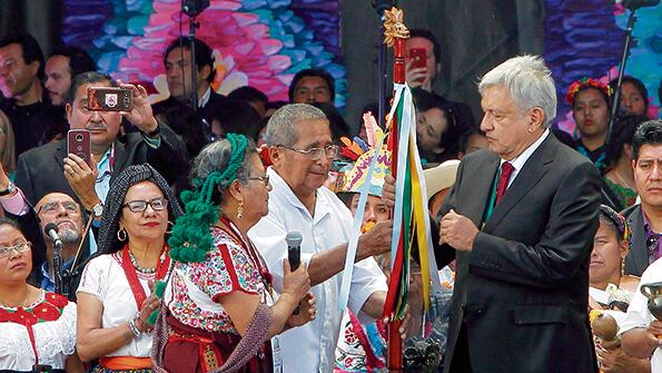 El presidente de México, Andrés López Obrador, recibe el bastón de Carmen Santiago.