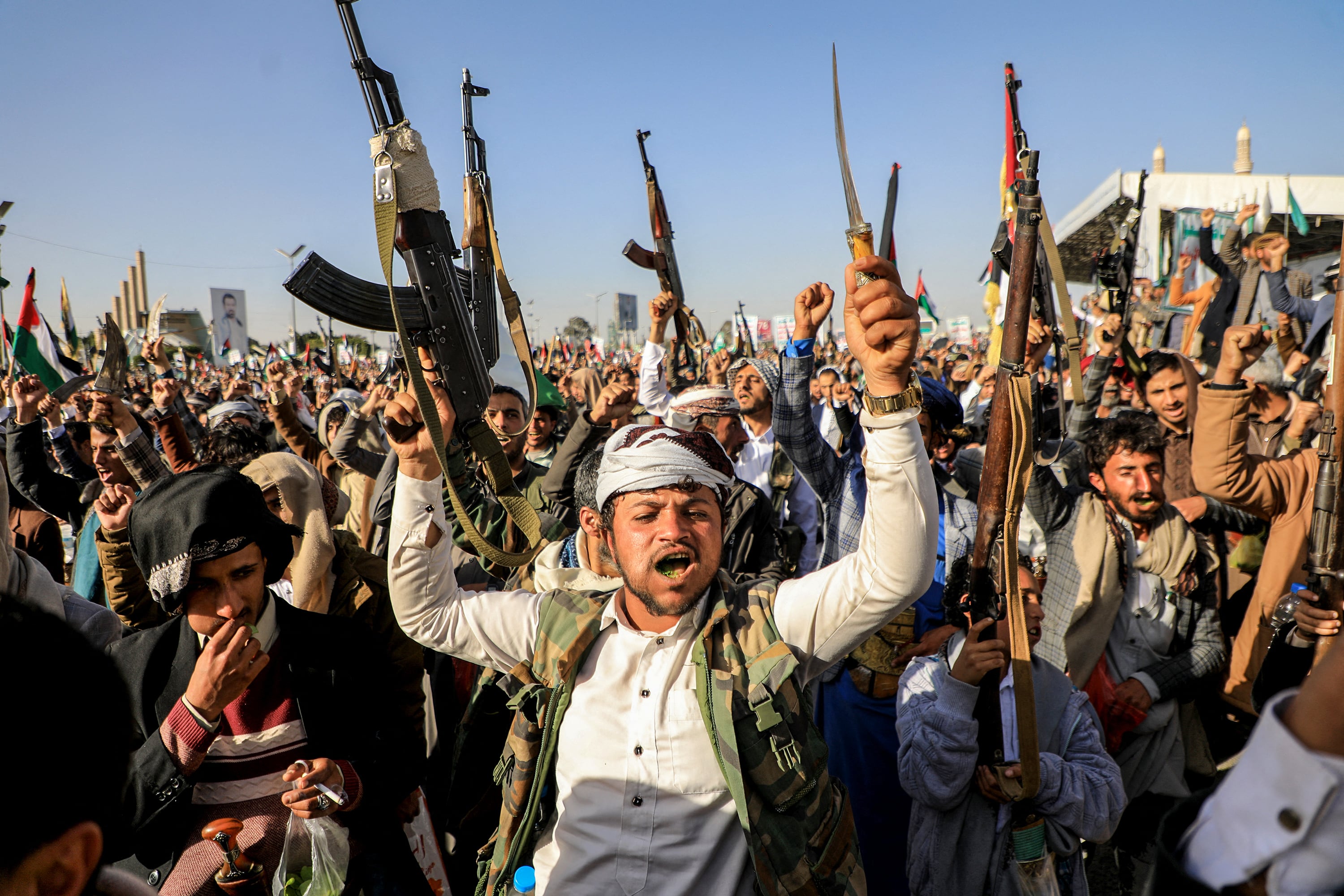 Milicianos hutíes alzan sus armas en protesta contra el bombardeo en Sanaa.