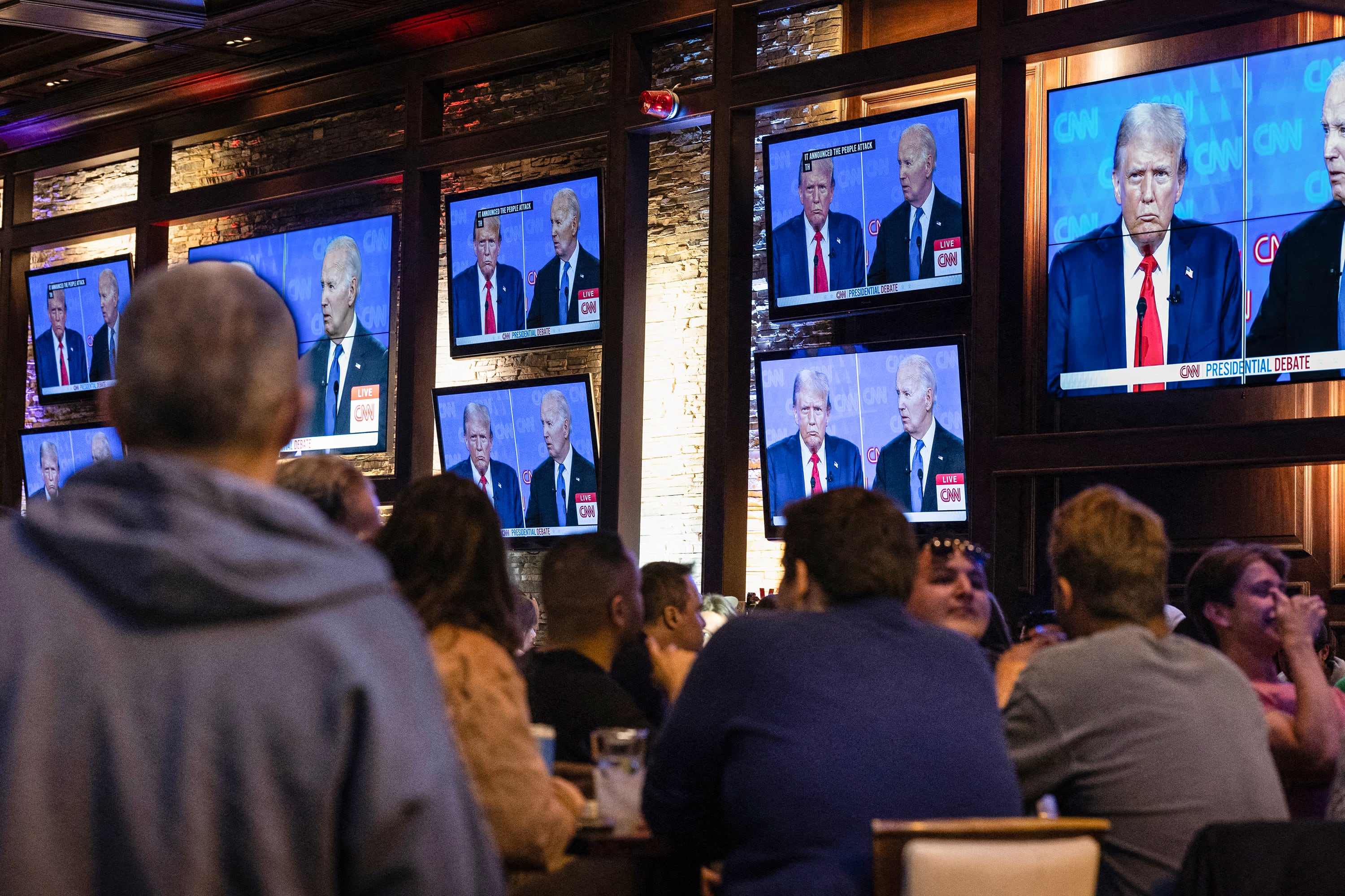 En un pub de Chicago varias personas siguen el debate presidencial. 