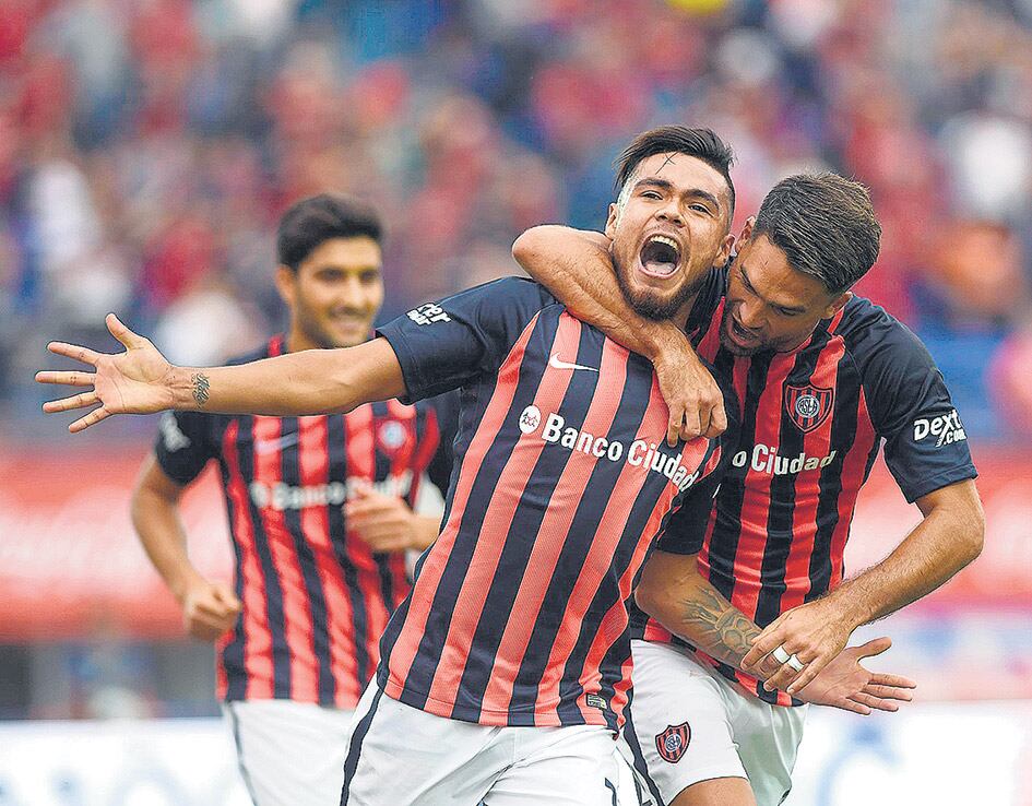 El abrazo de Caruzzo para el chileno Díaz, con su boca llena de gol. Blandi corre para sumarse al festejo.