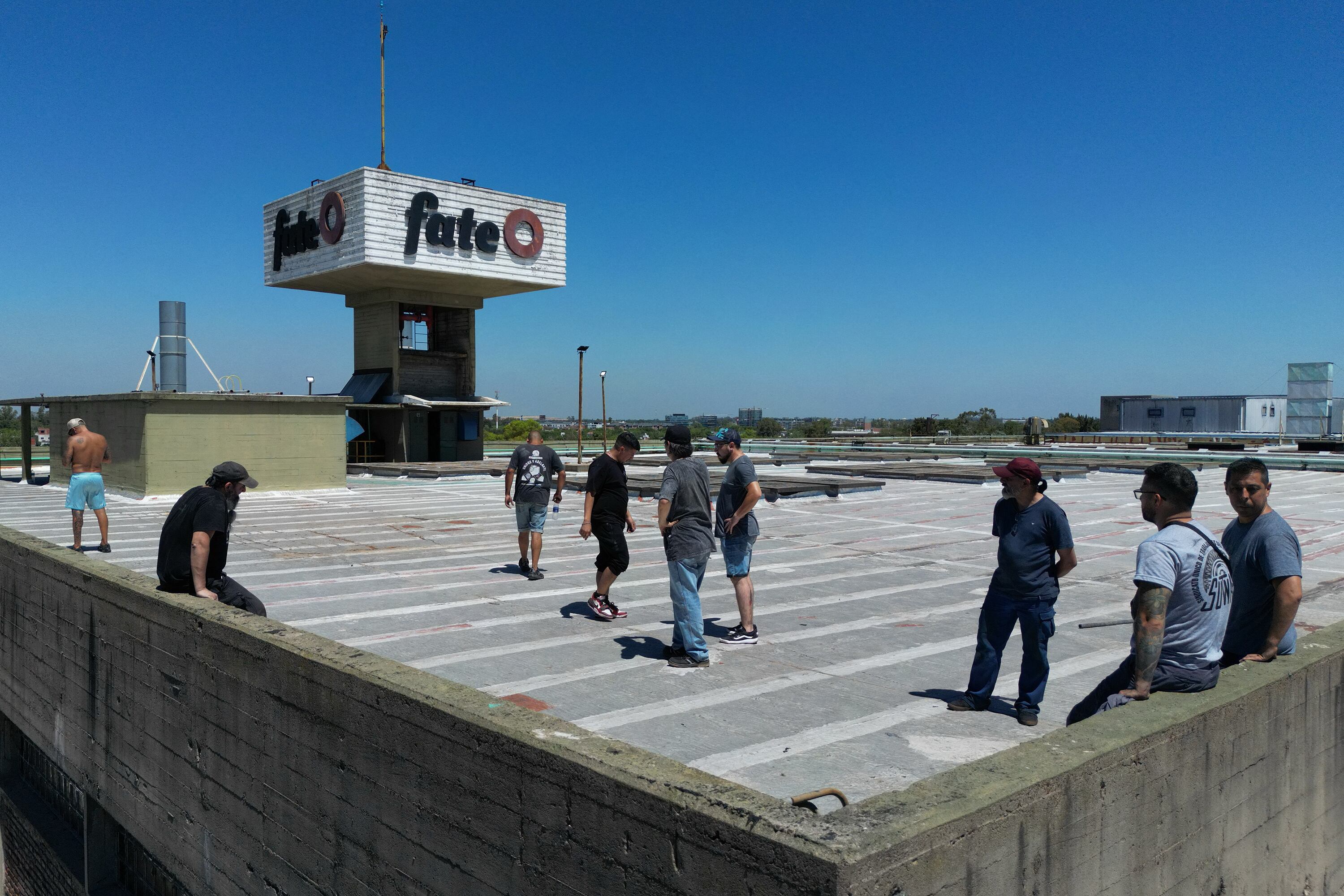 Workers of Argentine tyre company Fate stand atop the roof of the plant during a protest against the announcement of its closure