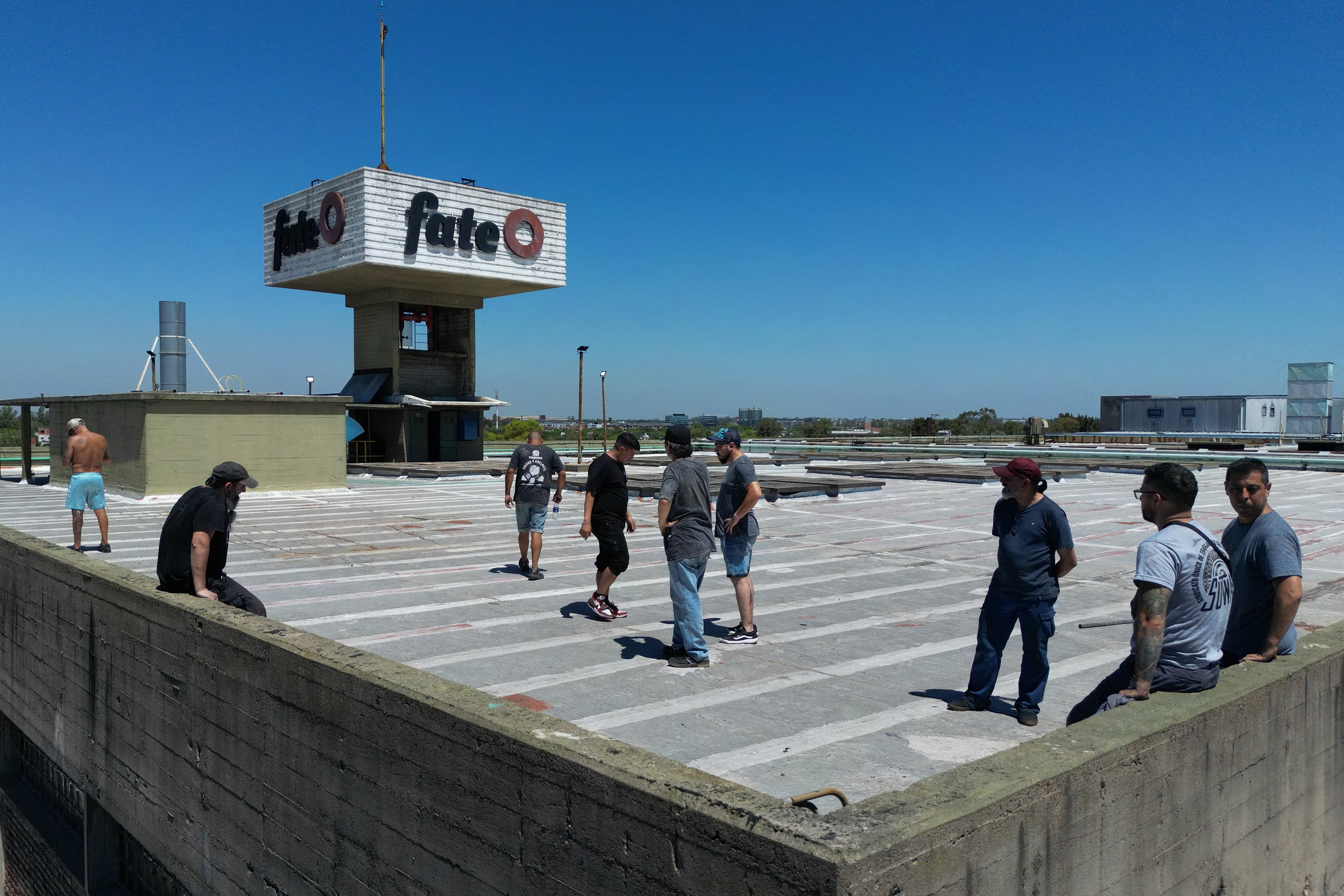 Workers of Argentine tyre company Fate stand atop the roof of the plant during a protest against the announcement of its closure