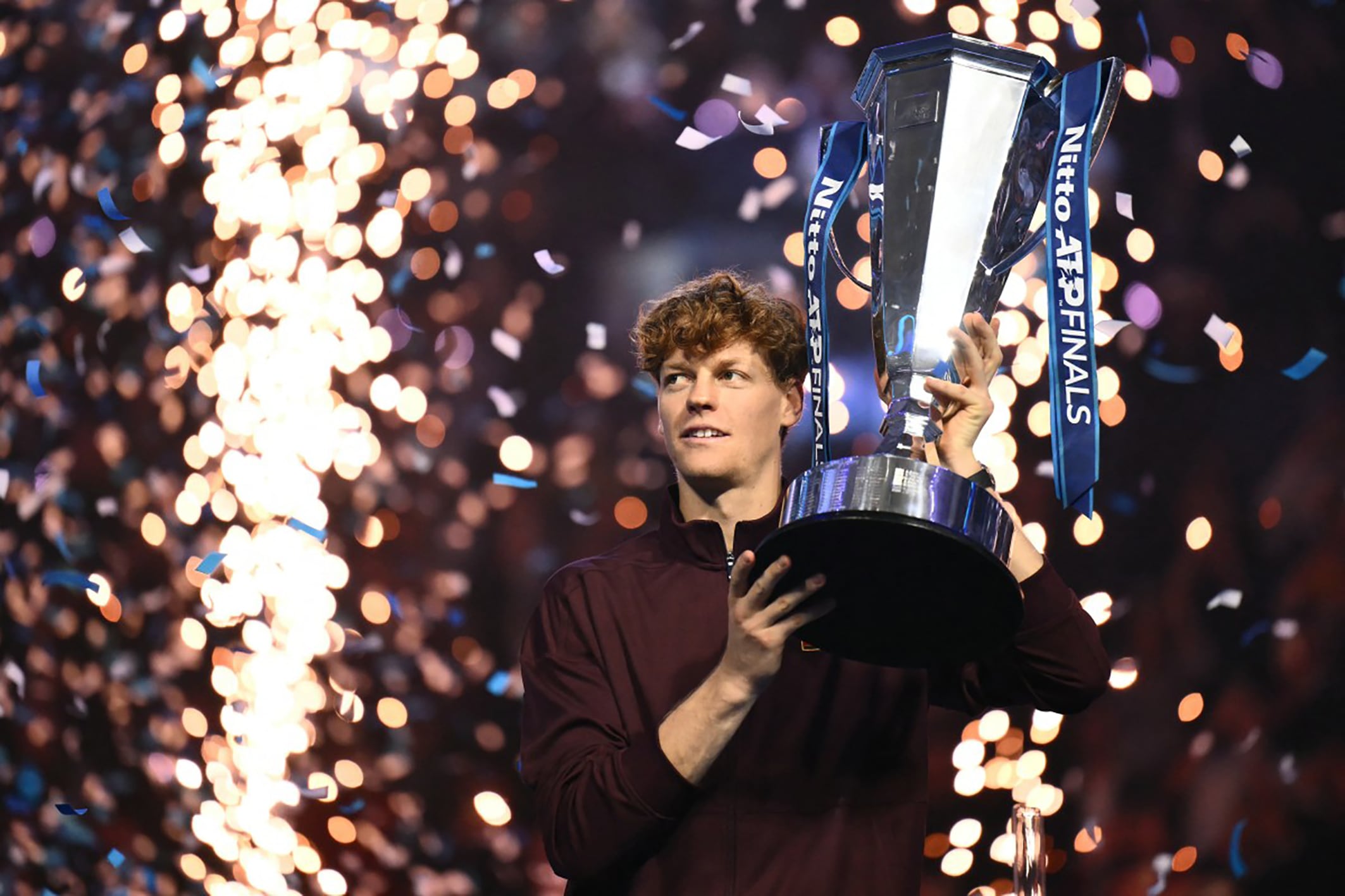 Italy's Jannik Sinner lifts the trophy after winning over Spain's Carlos Alcaraz at the end of the men's single final match at the ATP Finals tennis tournament, in Turin, on November 16, 2025. (Photo by Marco BERTORELLO / AFP)