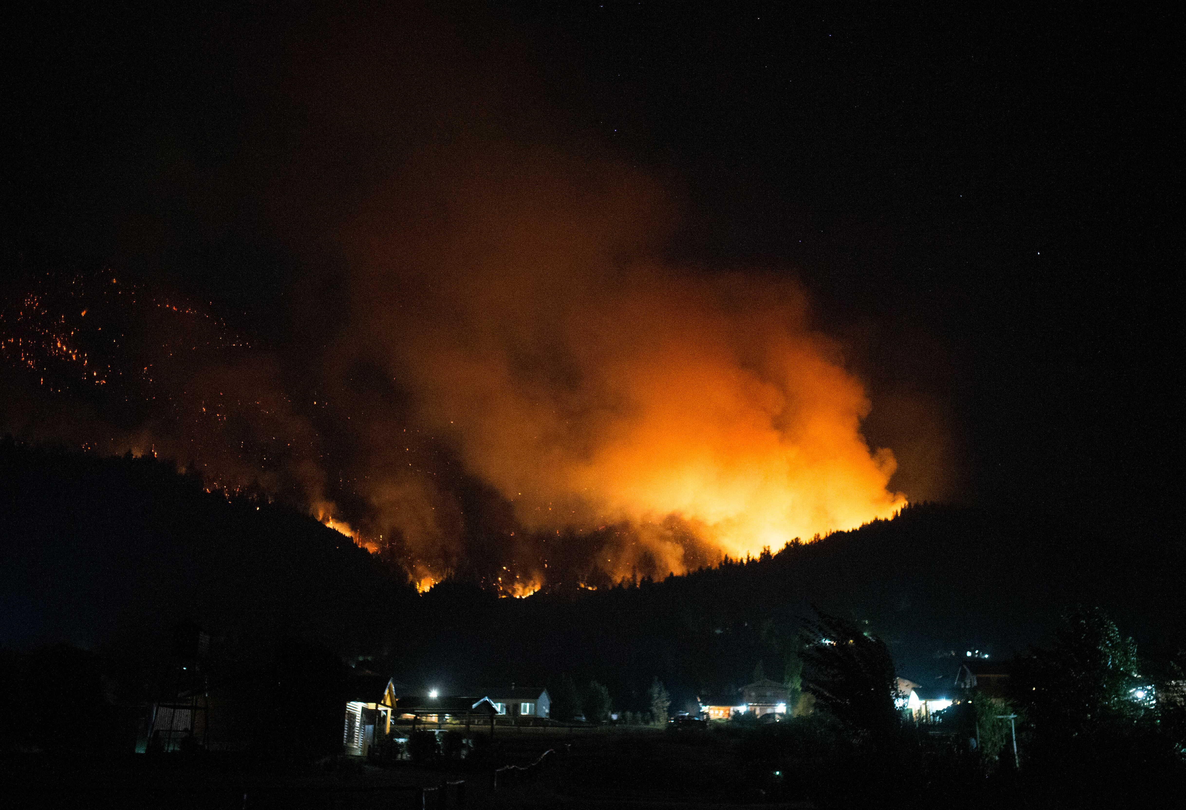 A forest fire is pictured engulfing Mount Pirque at El Hoyo, in the Patagonian region of Chubut province, Argentina on January 7, 2026. Thousands of hectares of forest were devastated by fire on January 6, in Argentine Patagonia, where a red alert is in effect due to extreme conditions, one year after the region experienced its worst wildfires in three decades. (Photo by Martin LEVICOY / AFP)