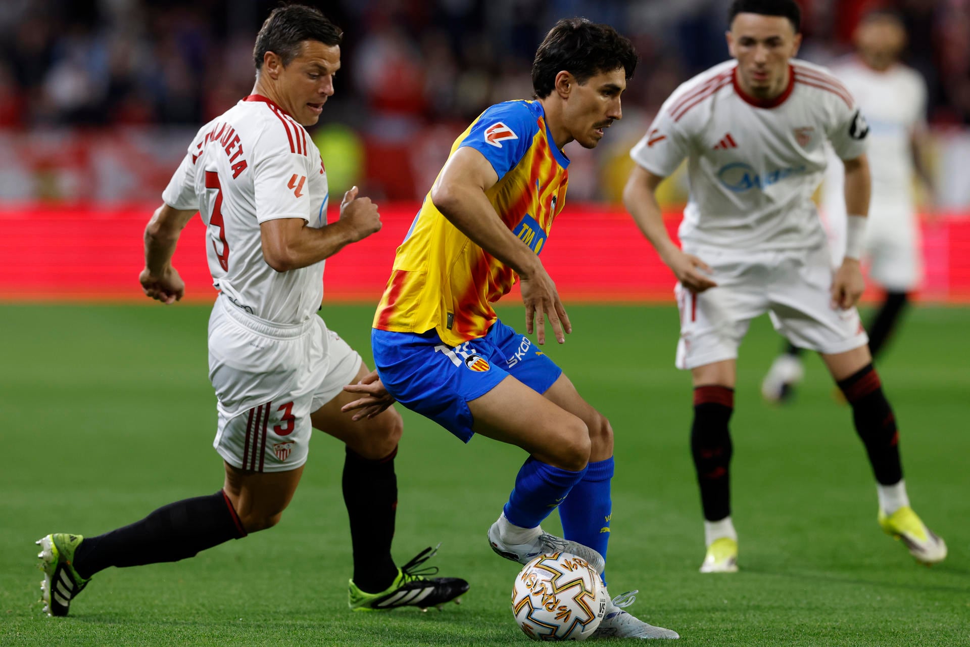21/03/2026.-El defensa del Sevilla César Azpilicueta y el centrocampista de Valencia André Almeida, durante el partido de la jornada 29 de LaLiga EA Sports entre Sevilla y Valencia, este sábado en el estadio Sánchez- Pizjuán en Sevilla.-EFE/ Julio Muñoz